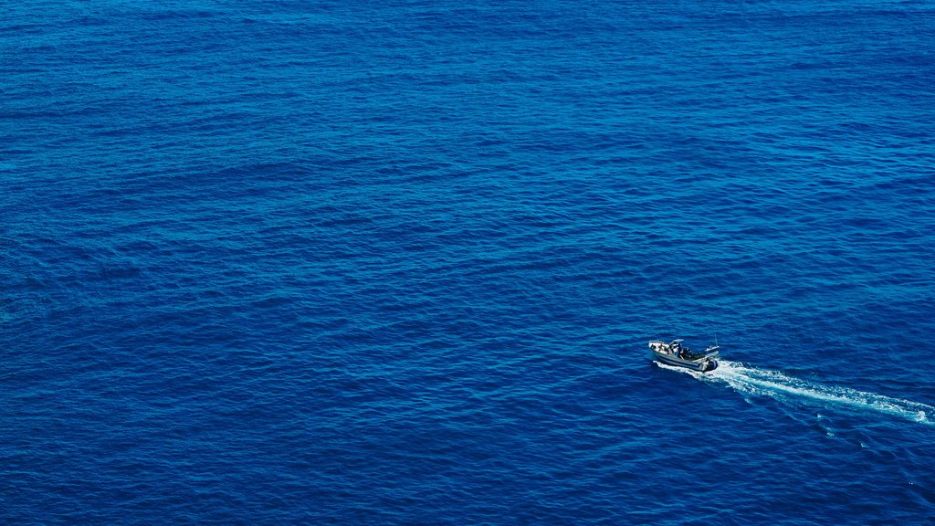 Large body of water. The water is a beautiful deep blue color with a boat crossing making a small wake.